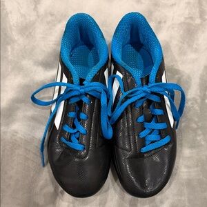 Adidas kids black Athletic cleats with Bright Blue Accents
